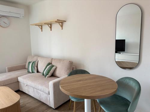 a living room with a couch and a table and a mirror at Studio 7 in Fos-sur-Mer