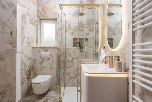 a bathroom with a sink toilet and a mirror at Villa Sky Stone, Heated Pool, Playground in Krstatice