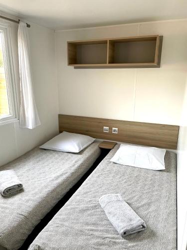 two twin beds in a room with a window at Le Soléa in Le Cailar