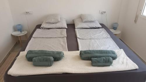 three beds in a hospital room with green pillows at Casa de la Luz del Sol in Mojácar