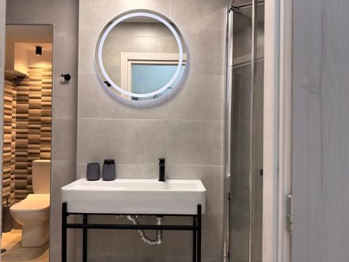 a bathroom with a white sink and a mirror at Electra Chios apartment in Chios