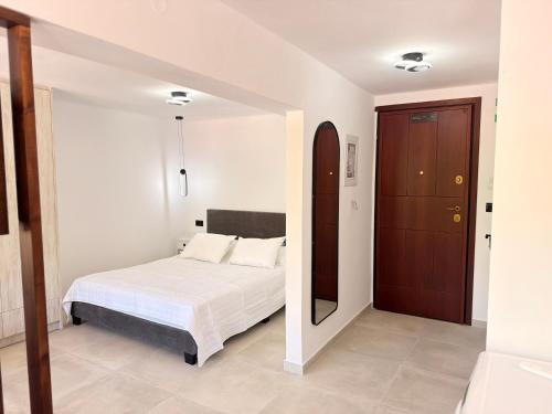 a bedroom with a white bed and a wooden door at Electra Chios apartment in Chios