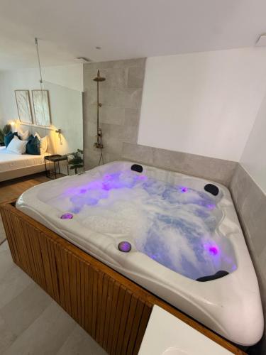a jacuzzi tub with purple lights in a room at Suite Canne Or in Bommes