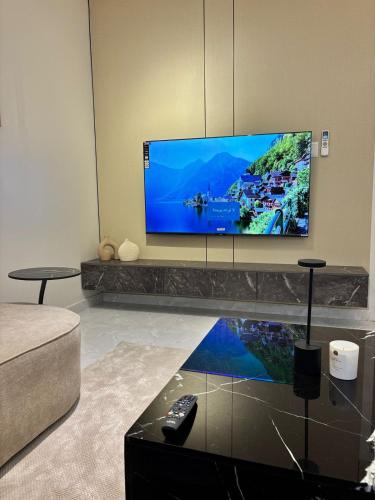 a living room with a flat screen tv on a wall at Bloom Home in Al Khobar