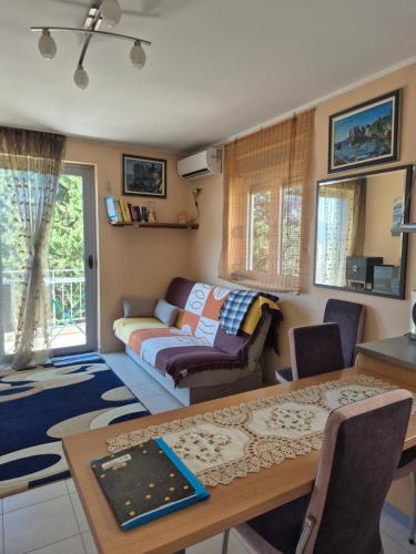 a living room with a table and a couch at Apartmani Bozenov in Petrovac na Moru