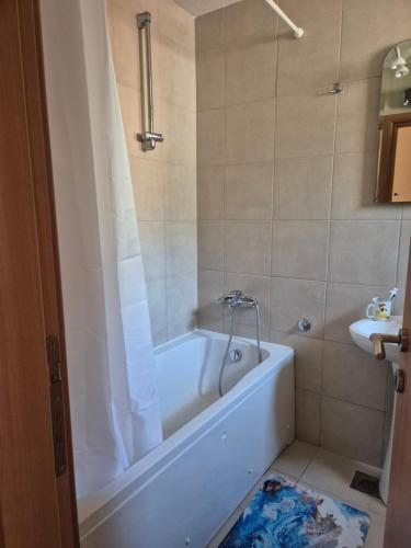 a bathroom with a white tub and a sink at Apartmani Bozenov in Petrovac na Moru