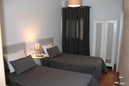 1 dormitorio con 2 camas y mesa con lámpara en Hostal Montilla Sotogrande en Torreguadiaro