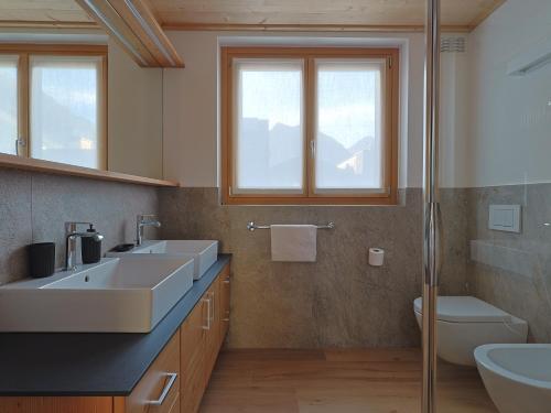 a bathroom with two sinks and a toilet at Bormio BM0 - Tutta Bormio a Zero stress in Bormio