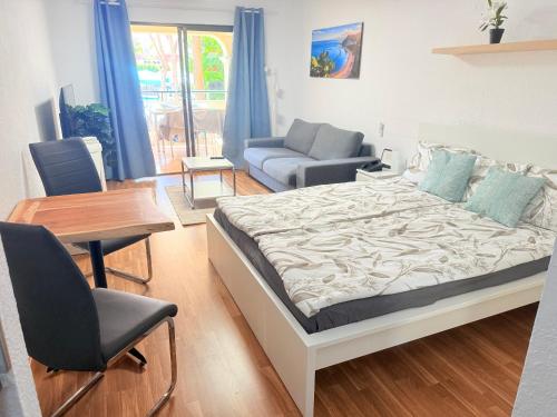 a bedroom with a bed and a couch and a table at Castle Harbour 209 in Los Cristianos