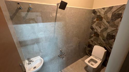 a bathroom with a toilet and a sink at JM Arunachala Stays in Tiruvannāmalai