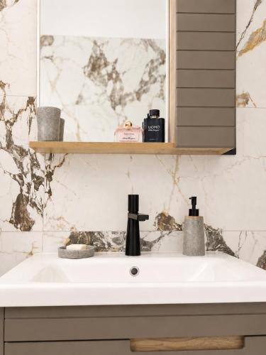 a white sink in a bathroom with a mirror at Retro Apartment Patras in Patra