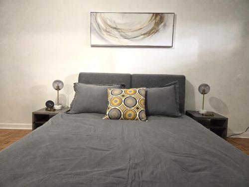 a bedroom with a bed with two end tables and two lamps at Where Comfort Meets Cozy Vibes in Montreal