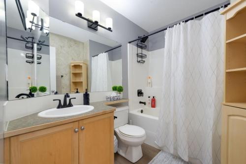 a bathroom with a sink and a toilet and a shower at Lake Life Landing in Sylvan Lake