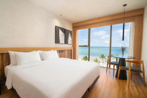 a bedroom with a bed and a view of the ocean at Sais Beach Living Hotel in Maceió