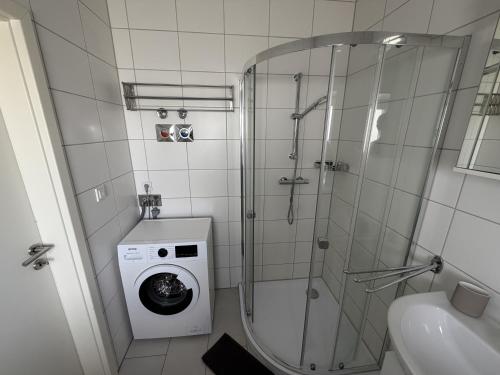 a bathroom with a shower and a washing machine at Apartment am Kalsmunt in Wetzlar