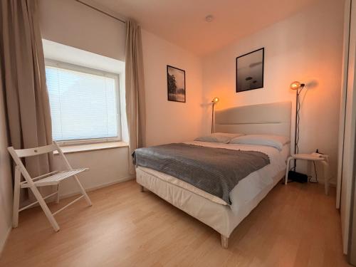 a bedroom with a bed and a chair and a window at Apartment am Kalsmunt in Wetzlar