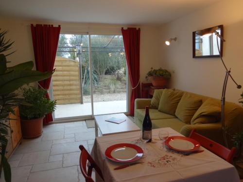 a living room with a table and a couch at La Pauseto in Fontvieille