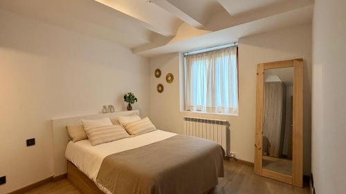 a bedroom with a large bed with a window at BPirineos-Mulleres in Benasque