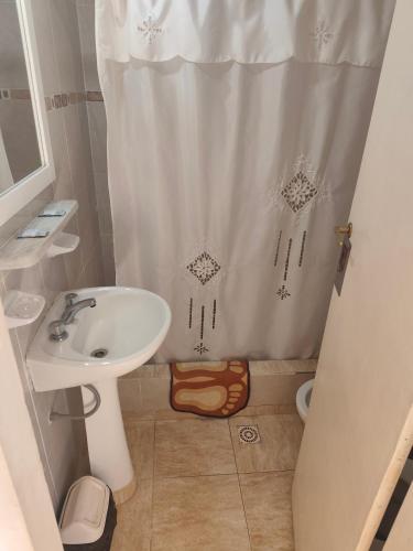 a bathroom with a sink and a shower curtain at Hospedaje Dos Soles - Centro in Termas de Río Hondo
