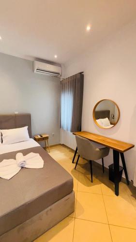 a bedroom with a desk and a bed and a mirror at Fay's Apartment in Limenas