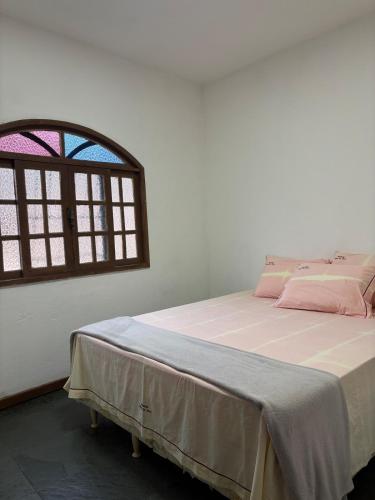 a bedroom with a bed and a window at Excelente apartamento espaçoso com terraço in Macaé