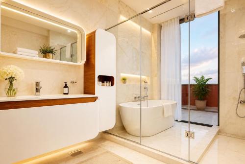 a bathroom with a tub and a sink and a shower at The Vynyard, Accra in Accra