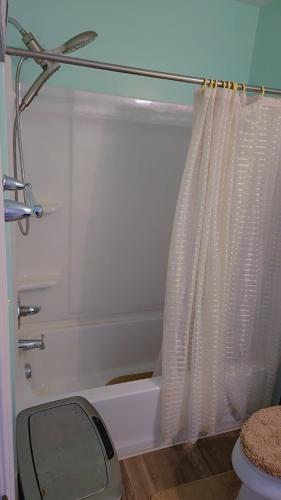 a bathroom with a tub and a shower curtain at North in Camby