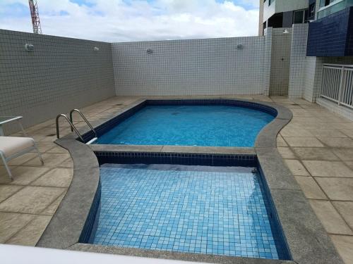 a swimming pool on the side of a building at Piscina aquecida e varanda, dois quartos com ar condicionado in Aracaju