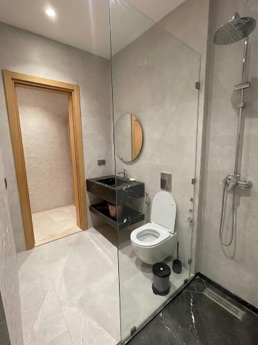 a bathroom with a toilet and a glass shower at Spinoza House Agadir City Apartment in Agadir