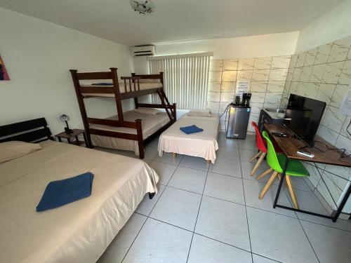 a room with two beds and a desk and a computer at casa la luz Orotina in Orotina
