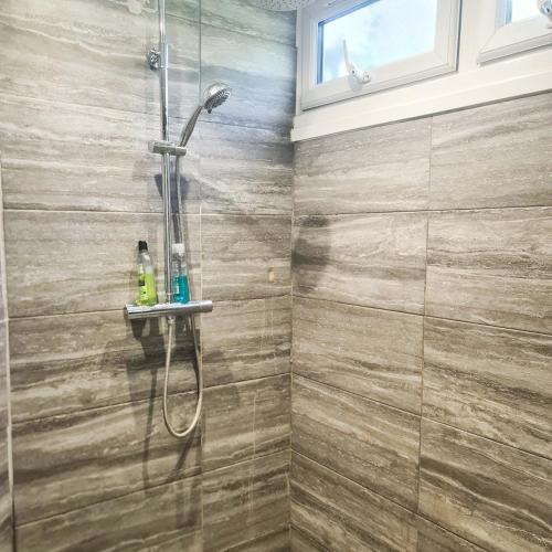 a bathroom with a shower with a glass door at Park View in Goodmayes