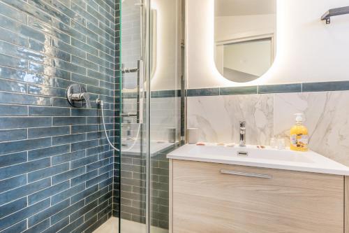 a bathroom with a sink and a shower with blue tiles at Fly&Rest Ciampino in Ciampino