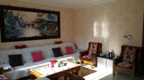 a living room with a couch and two chairs at Jumanyuan House in Miyun