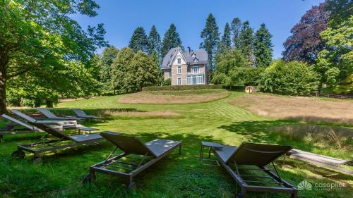 a group of lawn chairs in front of a house at Manoir Borzeux in Stavelot