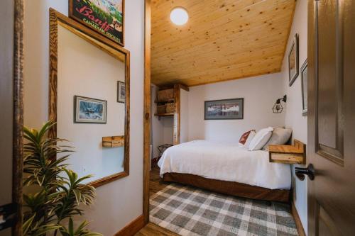 a bedroom with a bed and a mirror at Rustic Old West Cabin 1 Block to Beach Accessible Private Yard in Sylvan Lake
