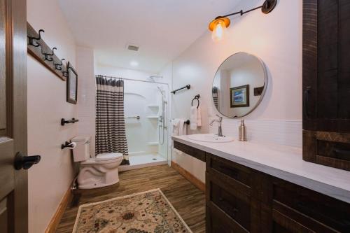 a bathroom with a sink and a toilet and a mirror at Rustic Old West Cabin 1 Block to Beach Accessible Private Yard in Sylvan Lake
