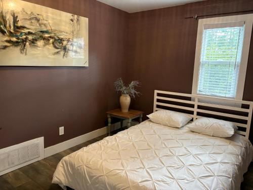 a bedroom with a bed and a painting on the wall at Brookswood Oasis - Guest suite,1 bedroom,1 den & 1 full bathroom in Langley