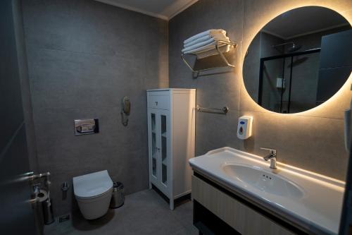 a bathroom with a sink and a mirror and a toilet at Demederon Hotel in Hamsikoy