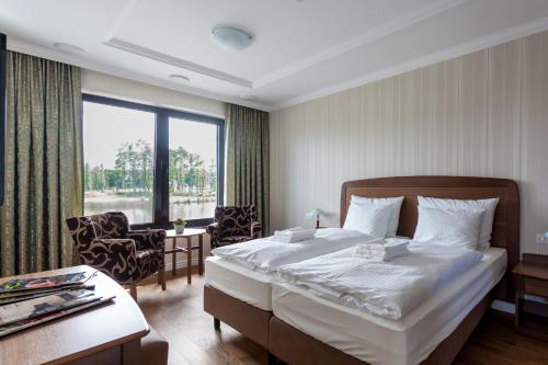 a hotel room with a bed and a large window at GolfBay Villa in Senica