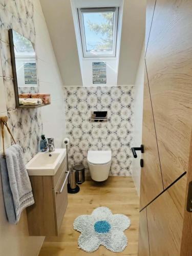 a bathroom with a sink and a toilet and a window at Fenyves Appartman in Pécsely