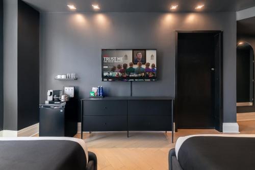 a living room with a flat screen tv on the wall at Madison Square Hotel Near NoMad in New York