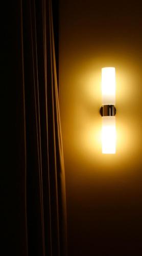 a light on a wall next to a curtain at Springbach-Mühle Belzig in Bad Belzig