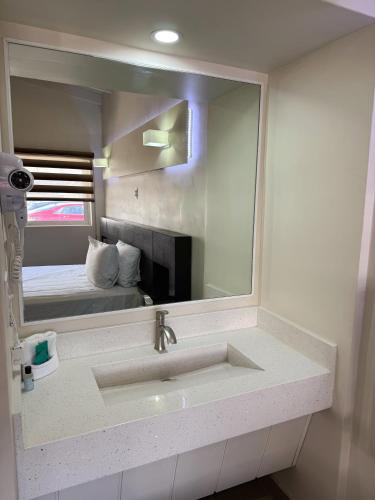 a bathroom with a sink and a large mirror at Motel Reno in Tijuana