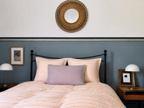 a bedroom with a large bed with a mirror on the wall at Maisonnette Clisson quartier Trinité in Clisson