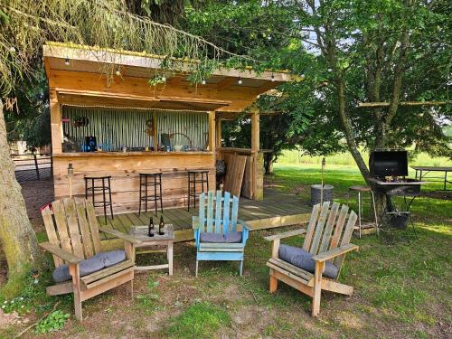 two chairs and a table in front of a cabin at appartement Plume de repos in Marboué