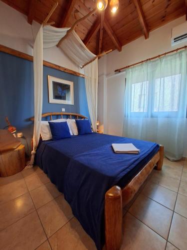 a bedroom with a large bed with a blue comforter at Blu Casa Del Mare in Monemvasia