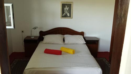 a bedroom with a bed with two pillows on it at Guesthouse Mala Venecija in Virpazar