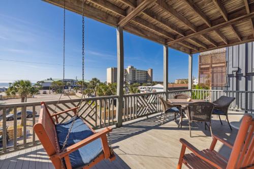 a patio with chairs and a table on a balcony at Beachwalk Villas 22 in Folly Beach