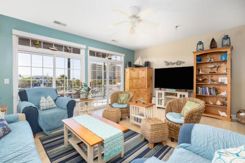 a living room with blue furniture and a flat screen tv at Beachwalk Villas 22 in Folly Beach