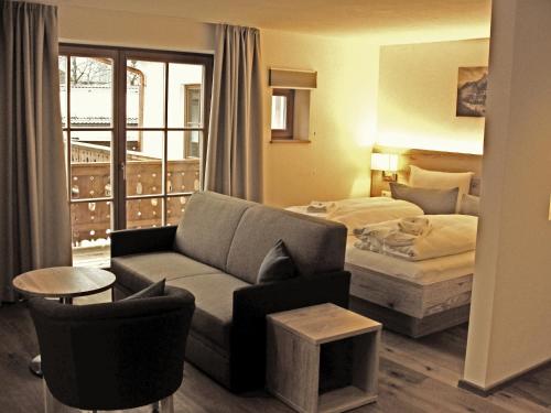une chambre d'hôtel avec un canapé et un lit dans l'établissement Mammhofer Suite & Breakfast, à Oberammergau